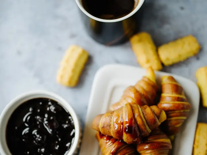Croissants mit Konfitüre und Kaffee