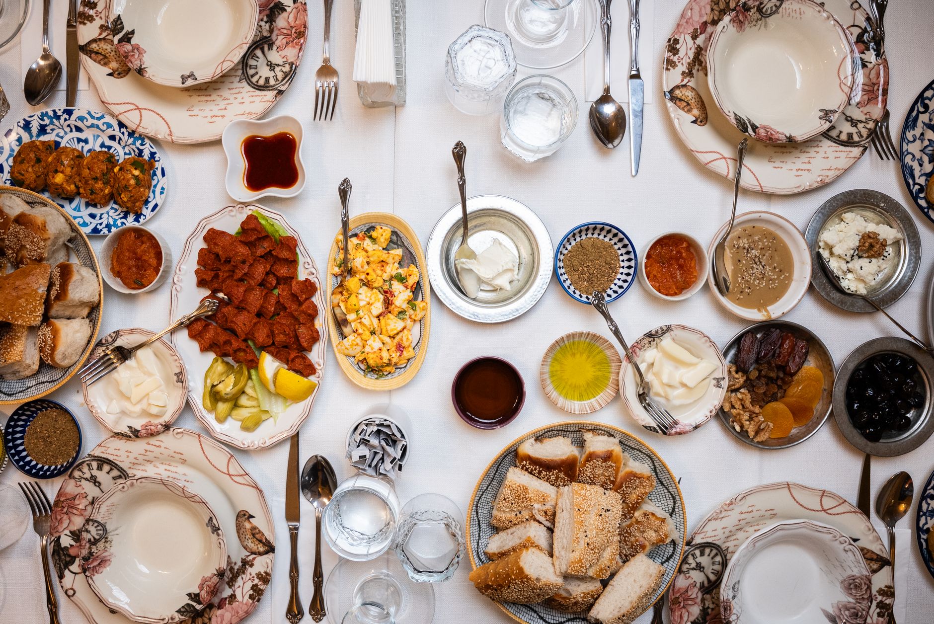 Eine reich gedeckte türkische Frühstückstafel aus der Vogelperspektive mit zahlreichen kleinen Schälchen, Oliven, Käsesorten und frischem Brot