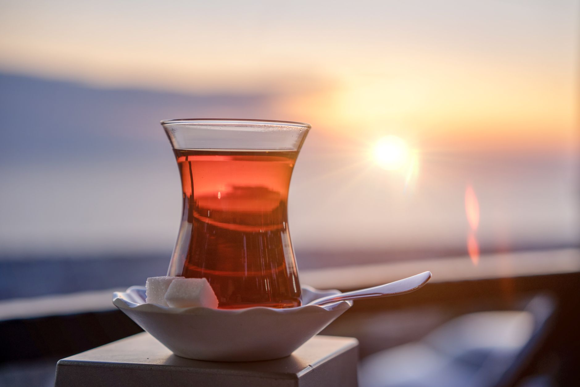 Ein Glas türkischer Tee mit Zuckerwürfeln in der Abendsonne