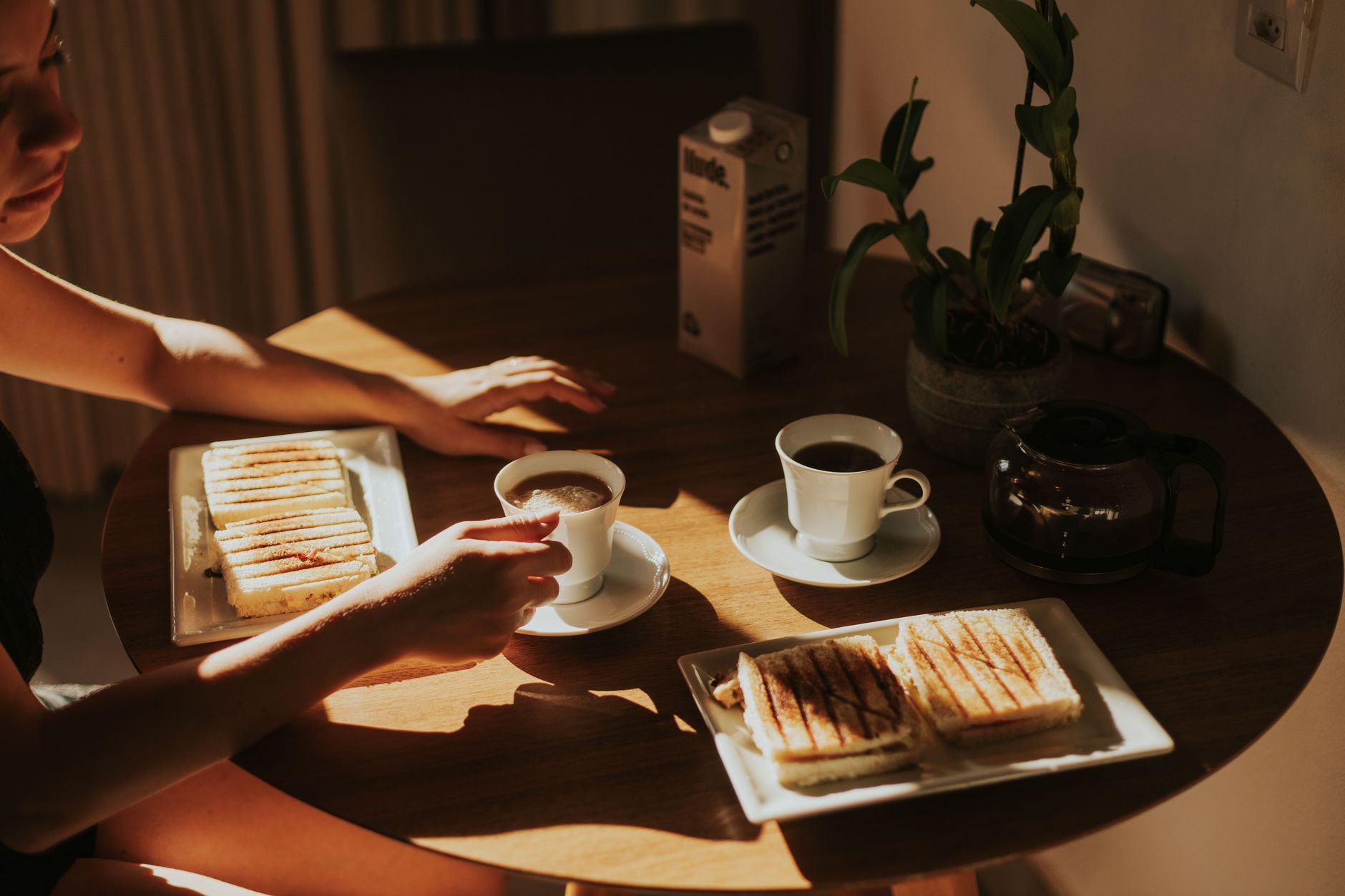 Ein gedeckter Frühstückstisch mit einer Tasse Kaffee und warmen Speisen im sanften Licht des frühen Morgens